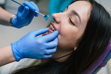 ortho-how-often-are-checkups mother paying an bill online while holding her toddler daughter